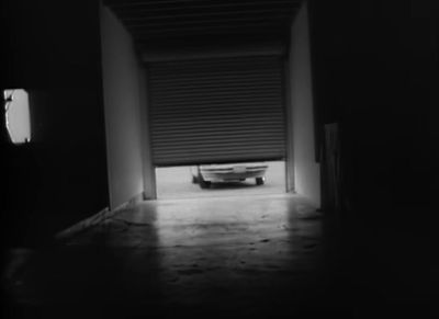 a black and white photo of a car in a garage