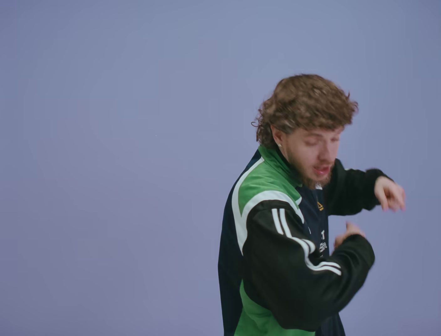 a man in a green and black jacket holding a white frisbee