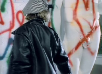 a man standing in front of a wall covered in graffiti