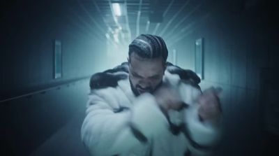 a man in a fur coat in a hallway