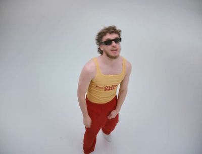 a man in a yellow tank top and red pants