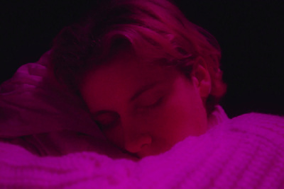 a child sleeping in a bed with a purple light