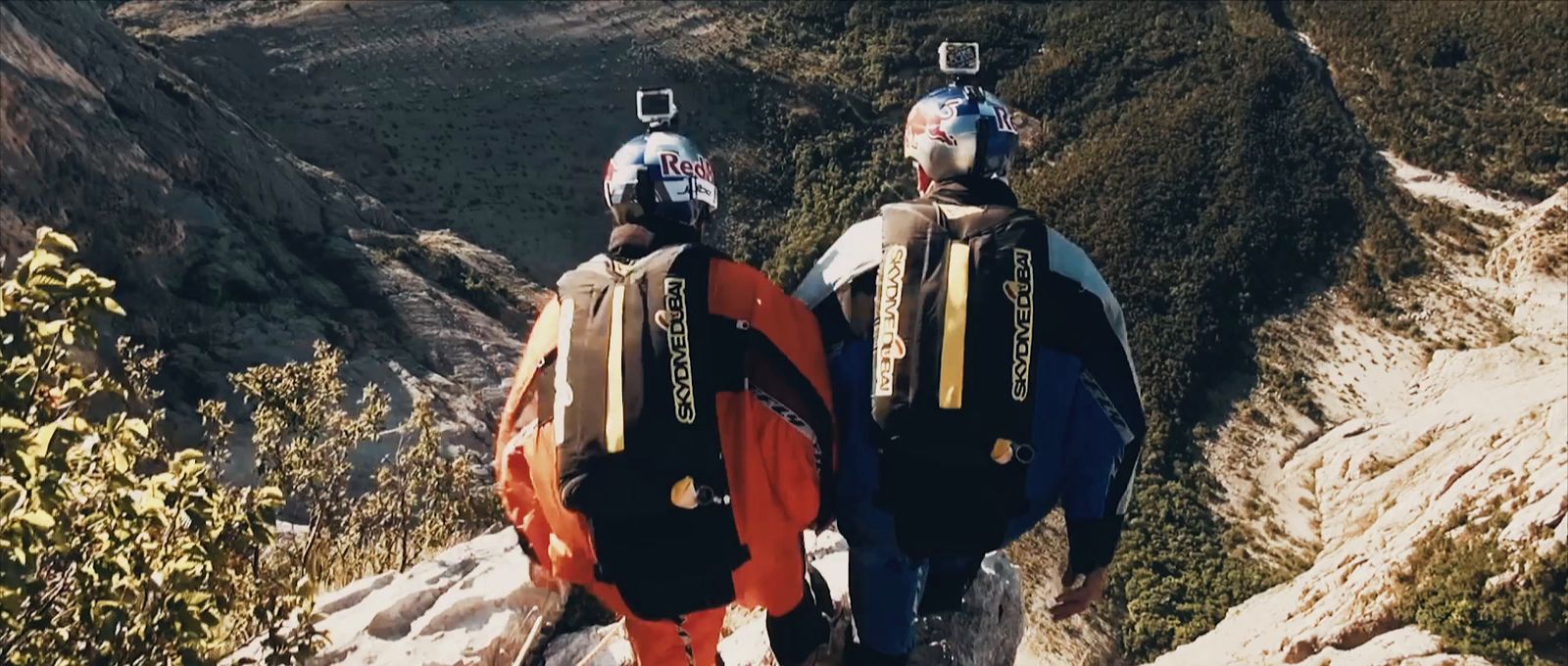 two people walking up a mountain with skis on