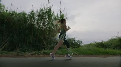 a woman running down a road in a sports bra