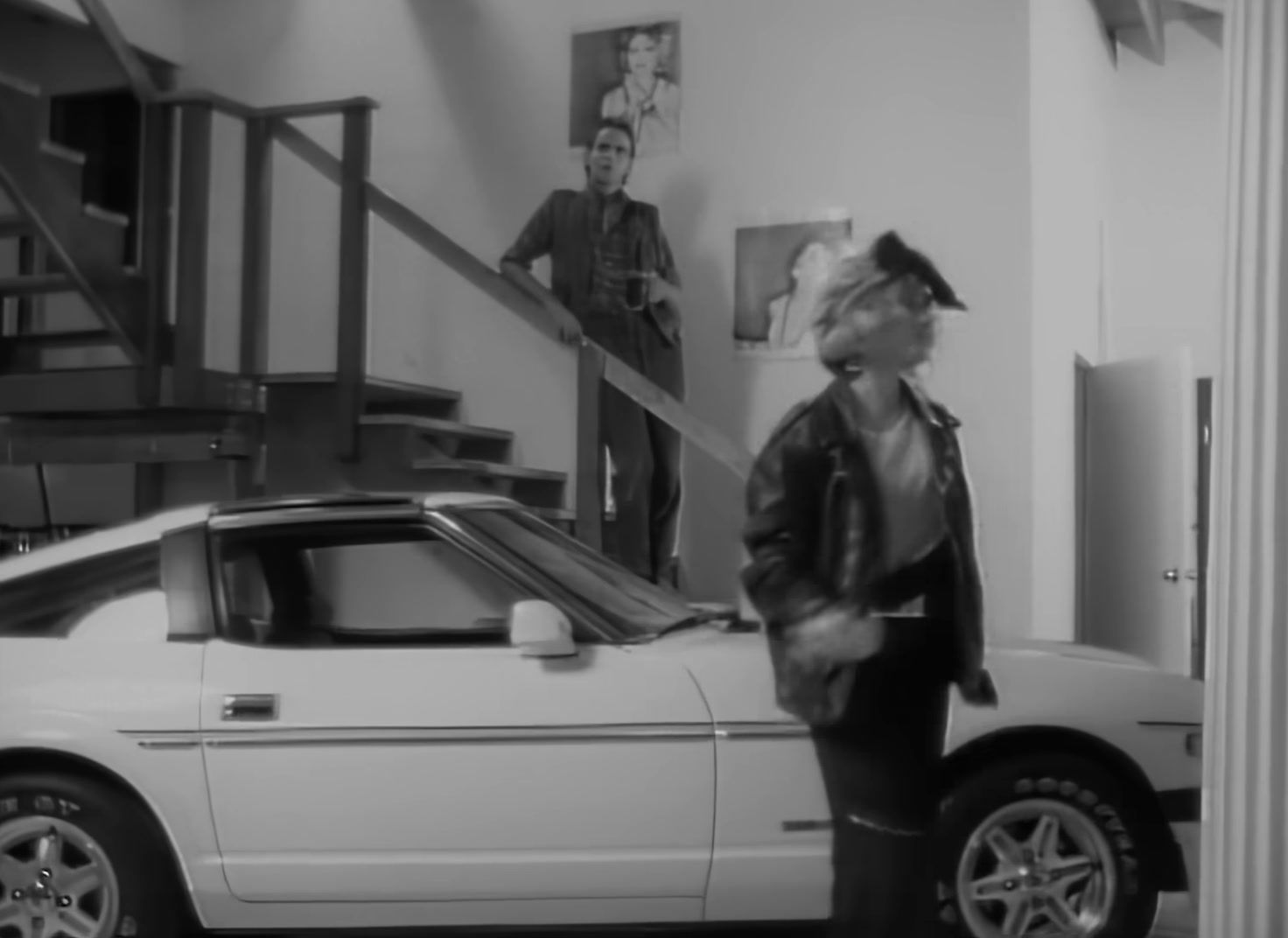 a woman standing next to a white car in a garage