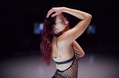 a woman with red hair wearing a fishnet bodysuit