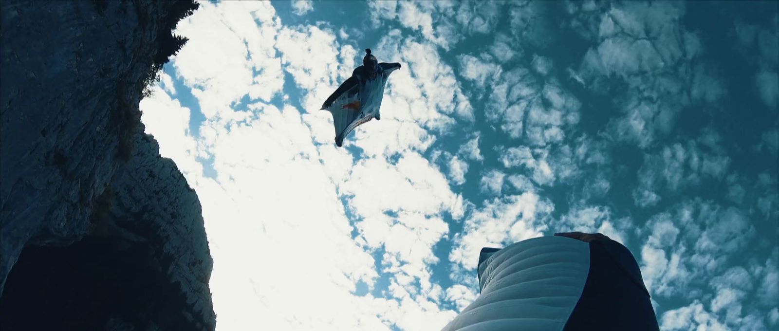 a person standing next to a jet flying in the sky