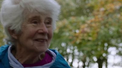 a woman with white hair and a blue jacket