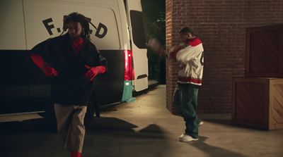 two men standing in front of a white van