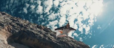 a man on a rock climbing up the side of a mountain