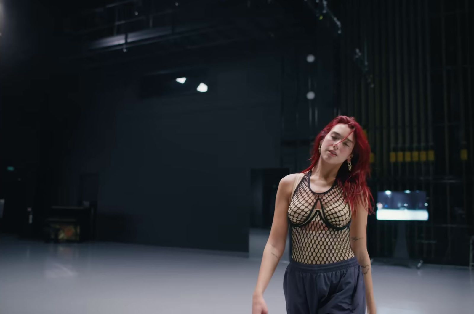 a woman with red hair standing in a dark room