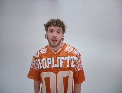 a man in an orange and white jersey holding a white frisbee