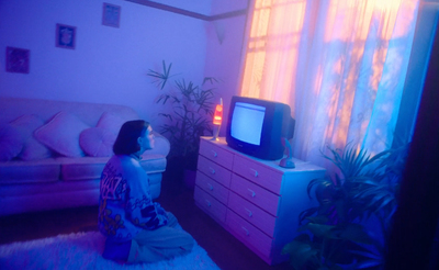 a woman sitting in front of a tv in a living room