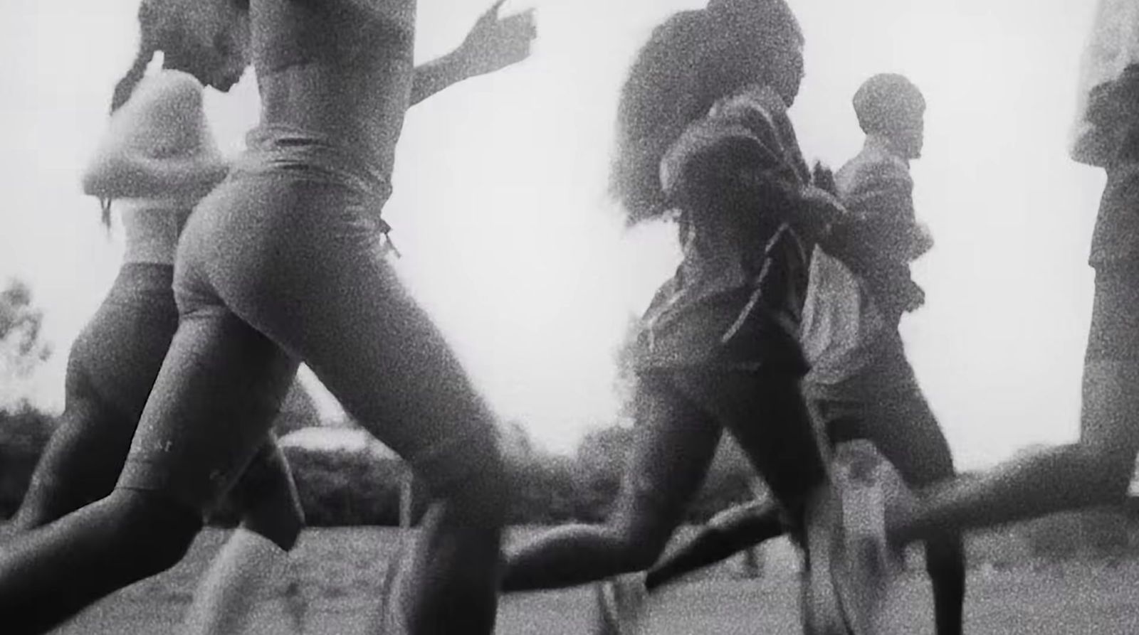 a black and white photo of a group of people running