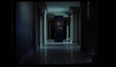 a dark hallway with columns and a fire hydrant