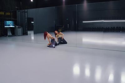 a couple of women standing on top of a white floor