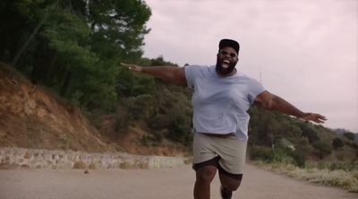 a man in white shirt and tan shorts on a skateboard