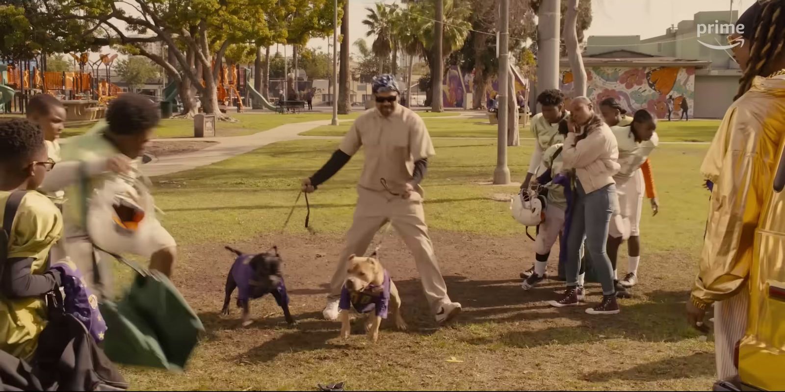 a group of people walking dogs in a park