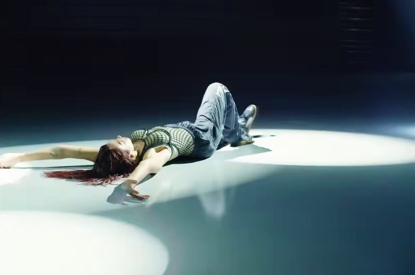 a woman laying on the ground with her head down