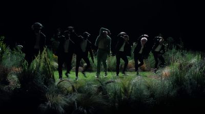 a group of people standing on top of a lush green field