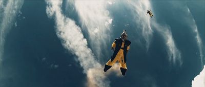 a fighter jet flying through a cloudy blue sky