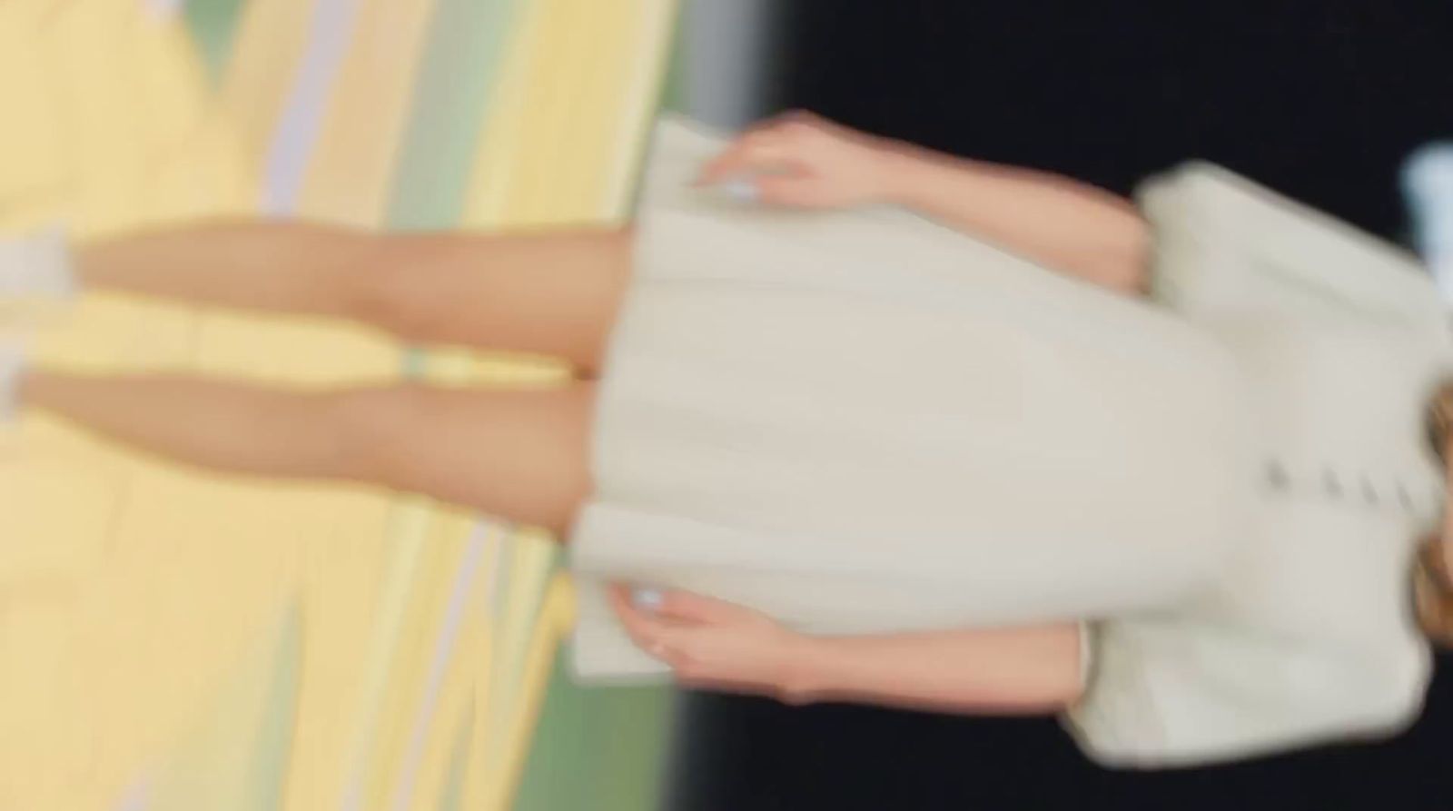 a woman in a white dress holding a white purse