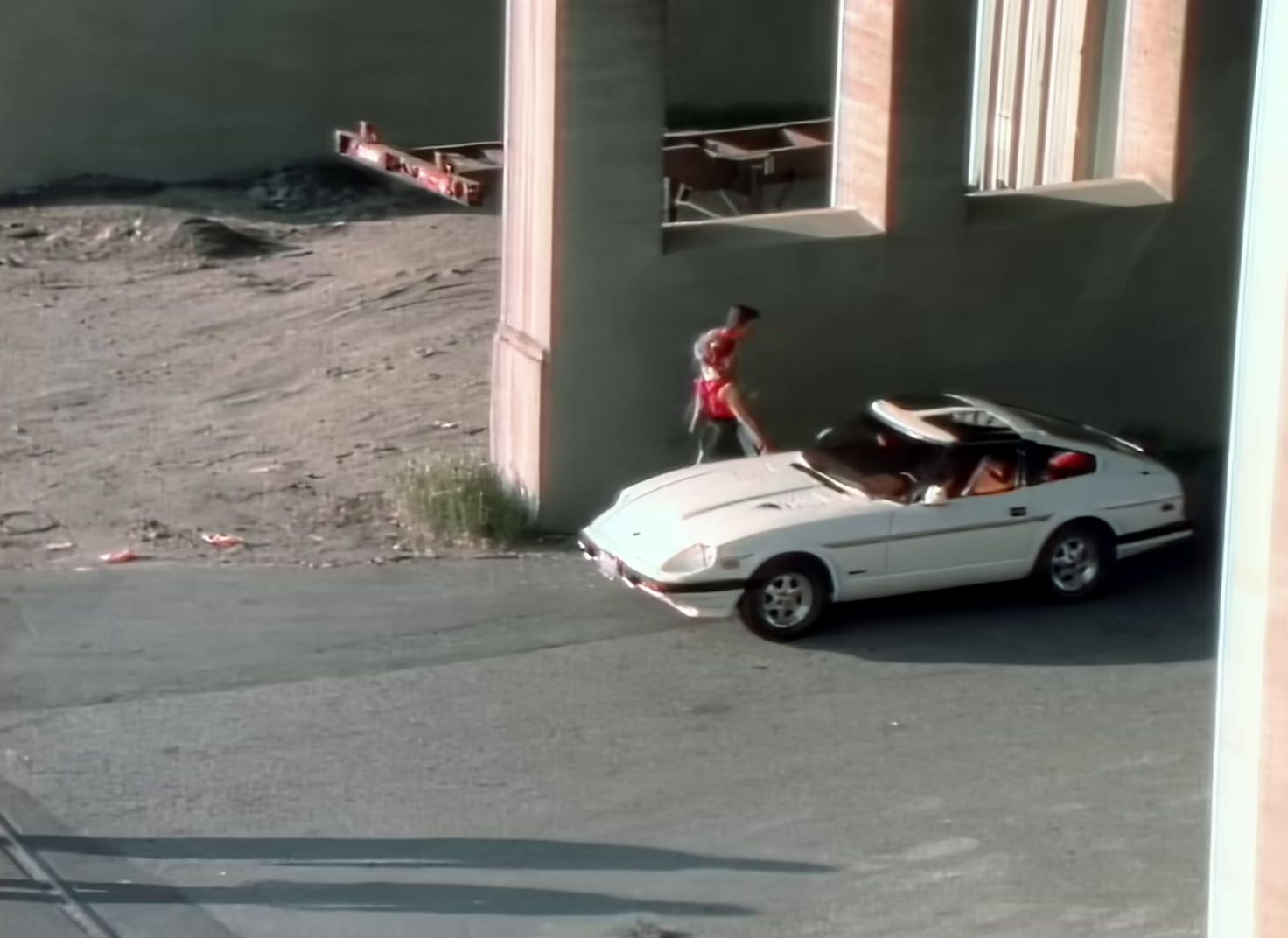 a white car parked on the side of a road next to a building