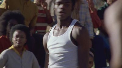 a man in a tank top standing in front of a crowd of people