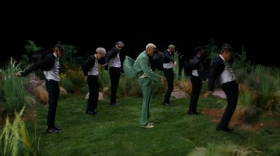 a group of men standing on top of a lush green field