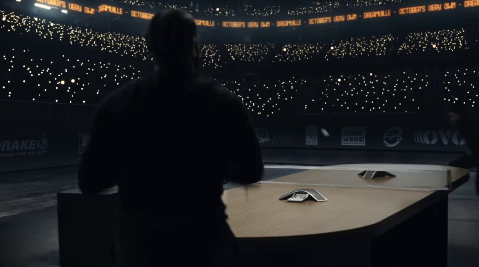 a man standing in front of a table with a cell phone on it