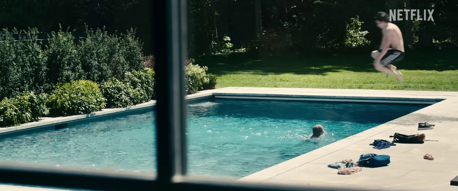 a man jumping into a swimming pool from a deck