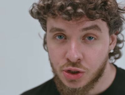 a man with curly hair making a surprised face