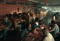 a group of people sitting at tables in a restaurant