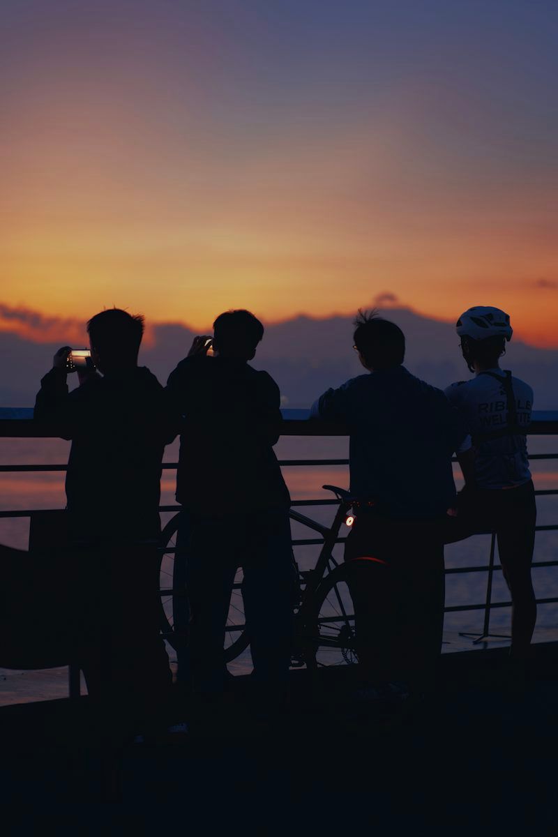 a group of people standing next to each other near a body of water