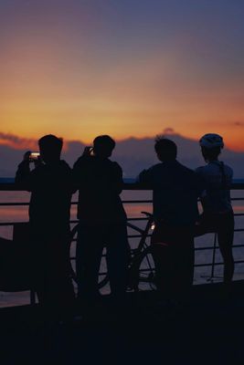 a group of people standing next to each other near a body of water