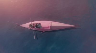 a pink boat floating on top of a body of water