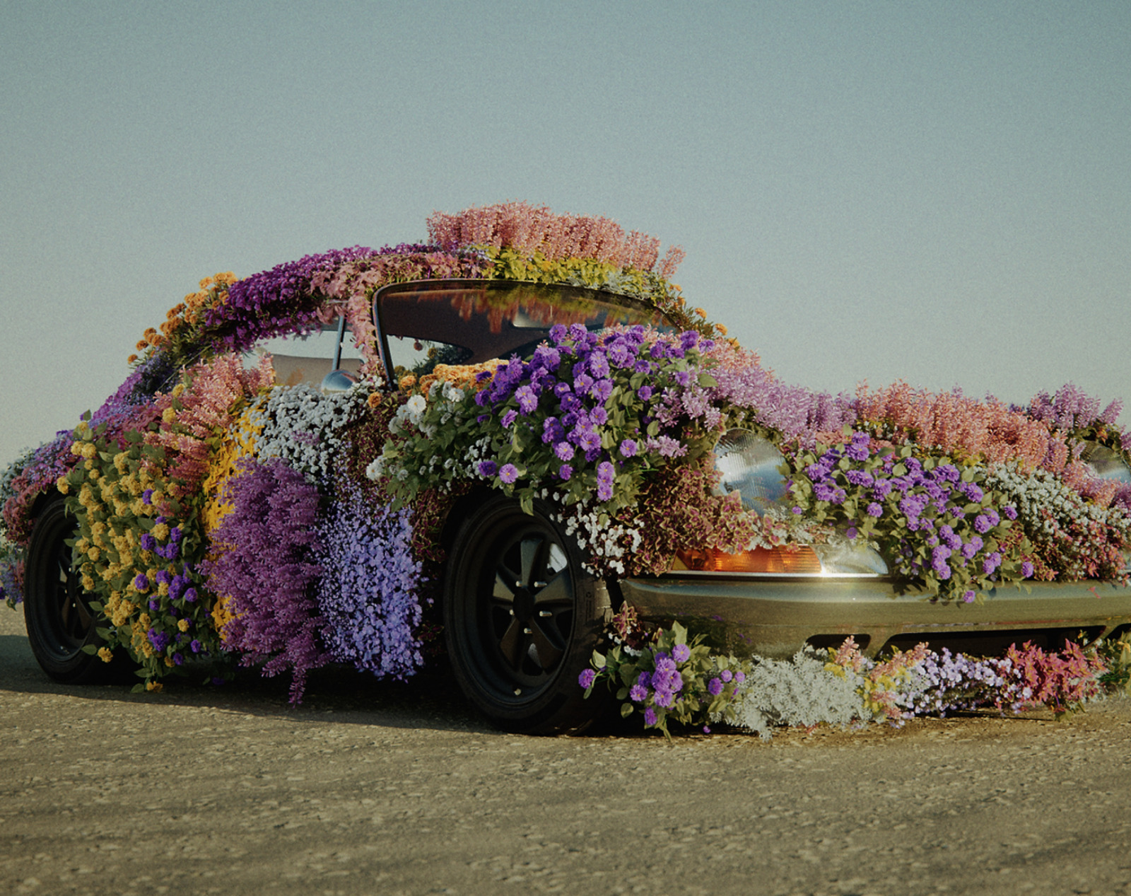 a car covered in flowers sitting on the side of a road