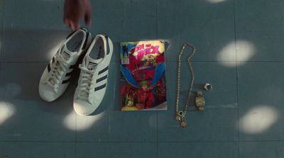 a pair of sneakers and a book on a tile floor