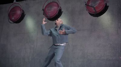 a man standing in front of three red speakers