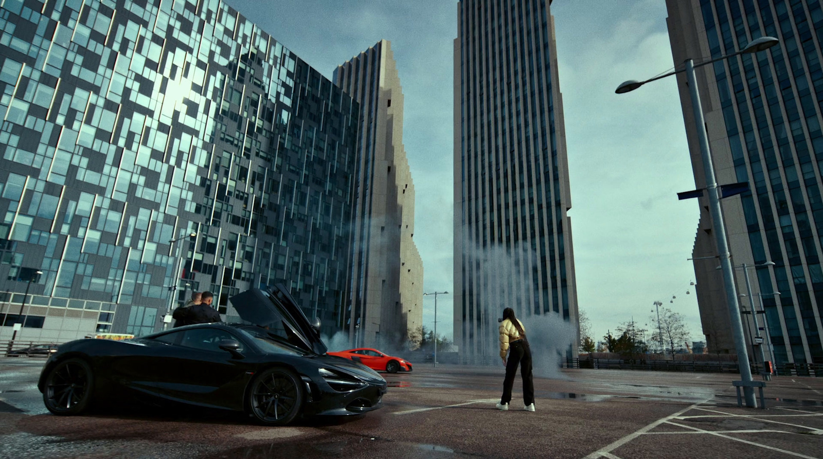 a man standing next to a black sports car