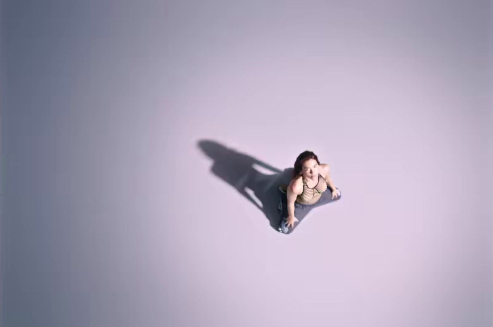 a woman laying on the ground with her shadow on the wall