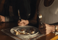 a man sitting at a table with a plate of food