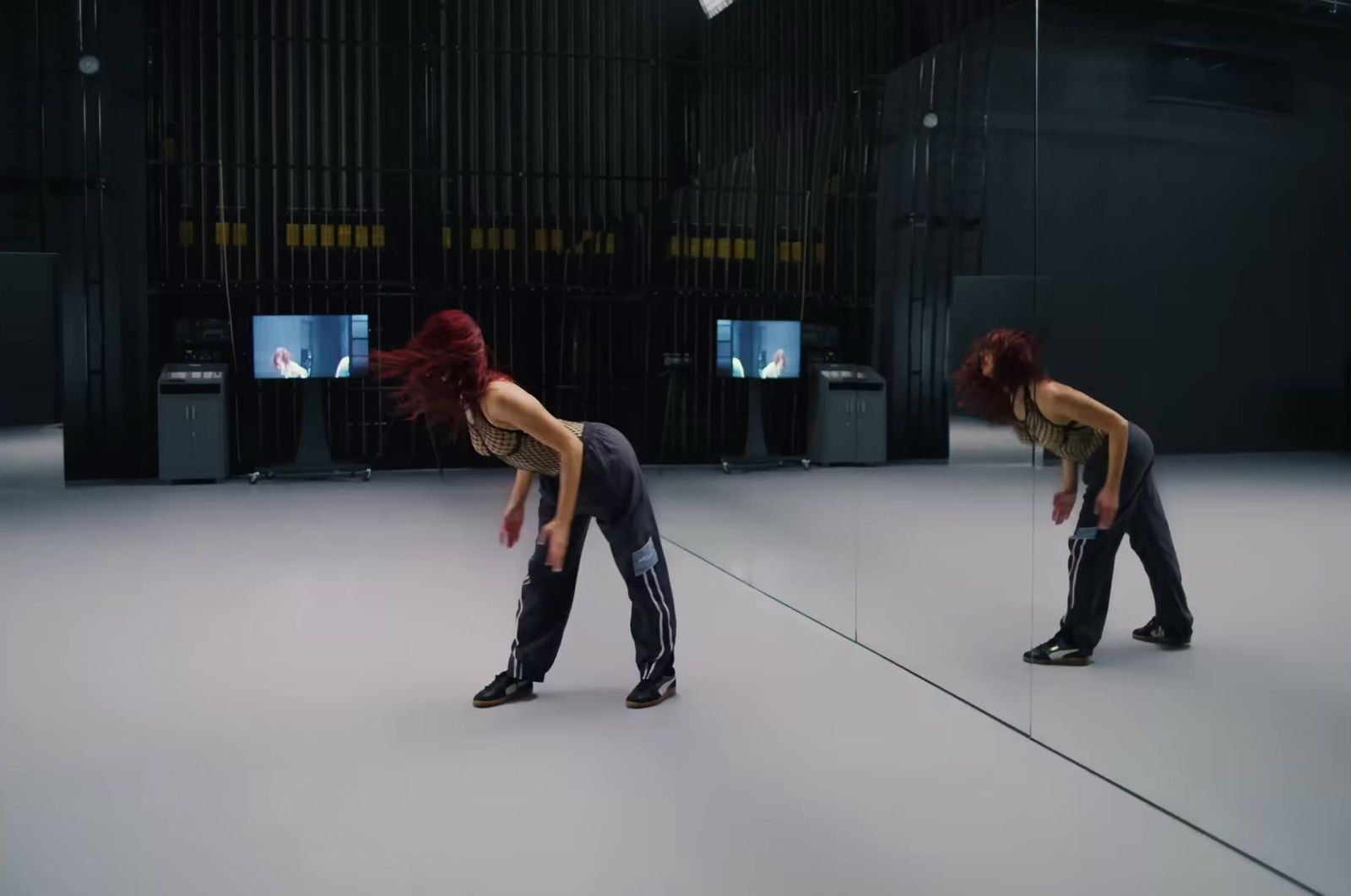 a woman with red hair standing in front of a mirror