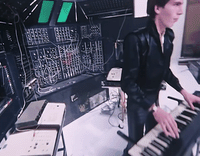 a man standing next to a keyboard in a room