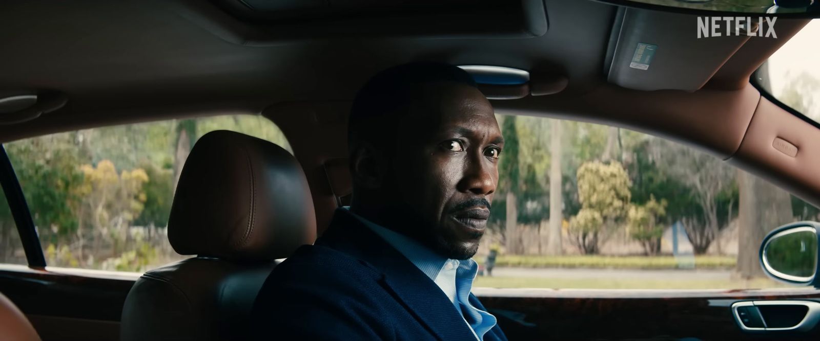 a man in a suit sitting in a car