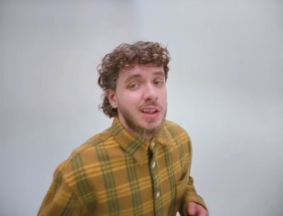 a man with curly hair wearing a yellow shirt and tie