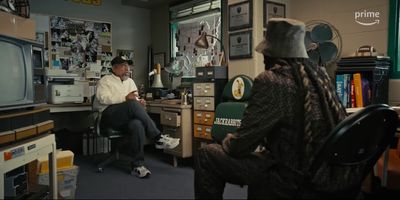 a man sitting in a chair in front of a tv