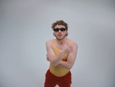 a man in a yellow tank top and red pants