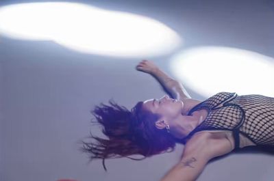 a woman in a fishnet dress is flying through the air