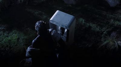 a man with his head in a box in the dark